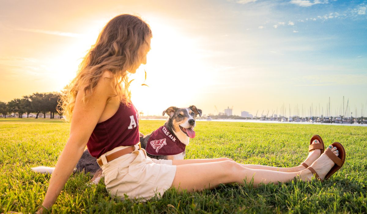 A girl and her senior dog sit in the grass on Davis Islands Tampa in a photo taken by Hello Hound Dog Photographer